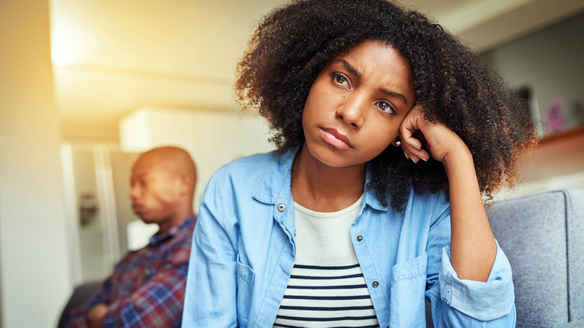 Woman looking upset turned away from a man.