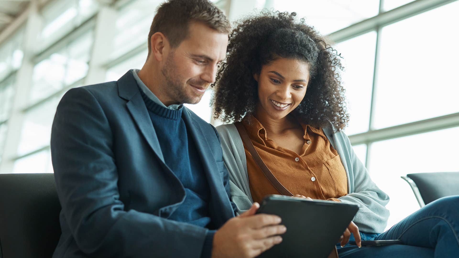 Co-workers looking at a tablet together and smiling