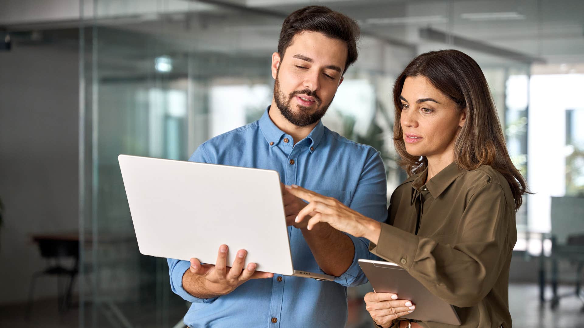 Co-workers talking and pointing at a tablet