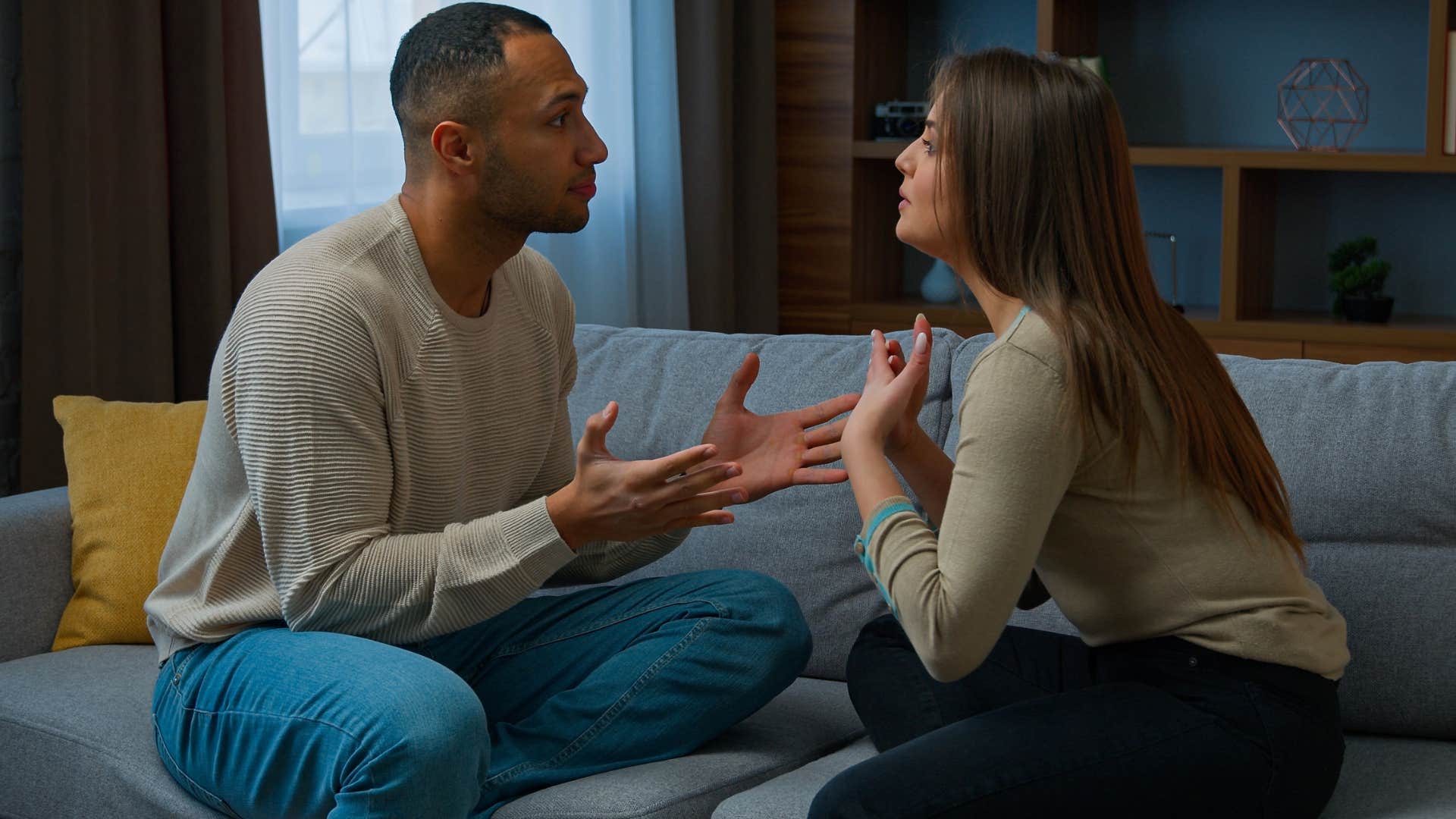 Couple arguing on the couch together.