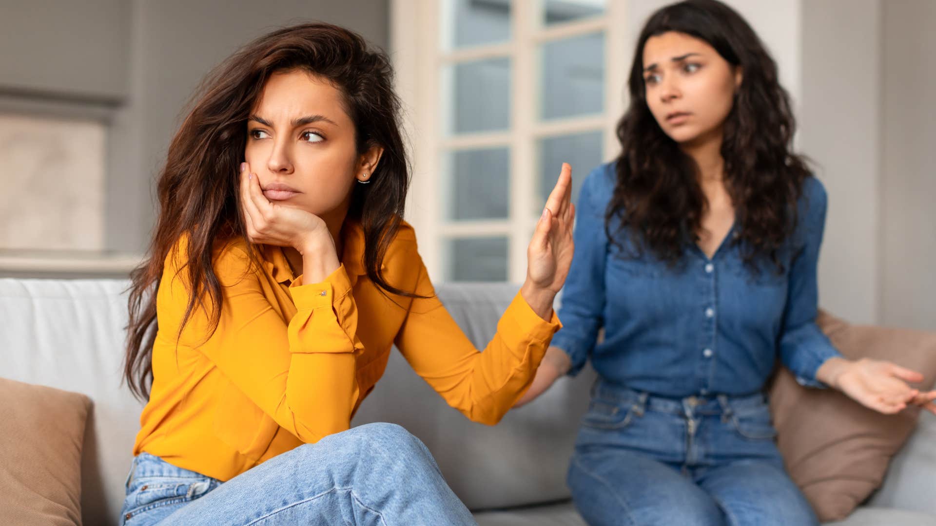 Woman turned away and holding her hand up to a friend.