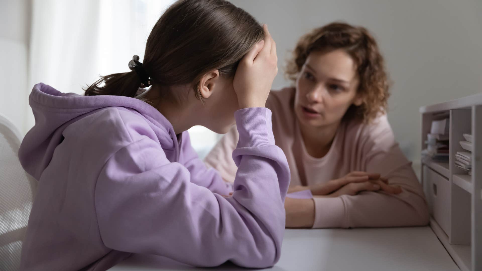 Mother talking to her upset teenage daughter.