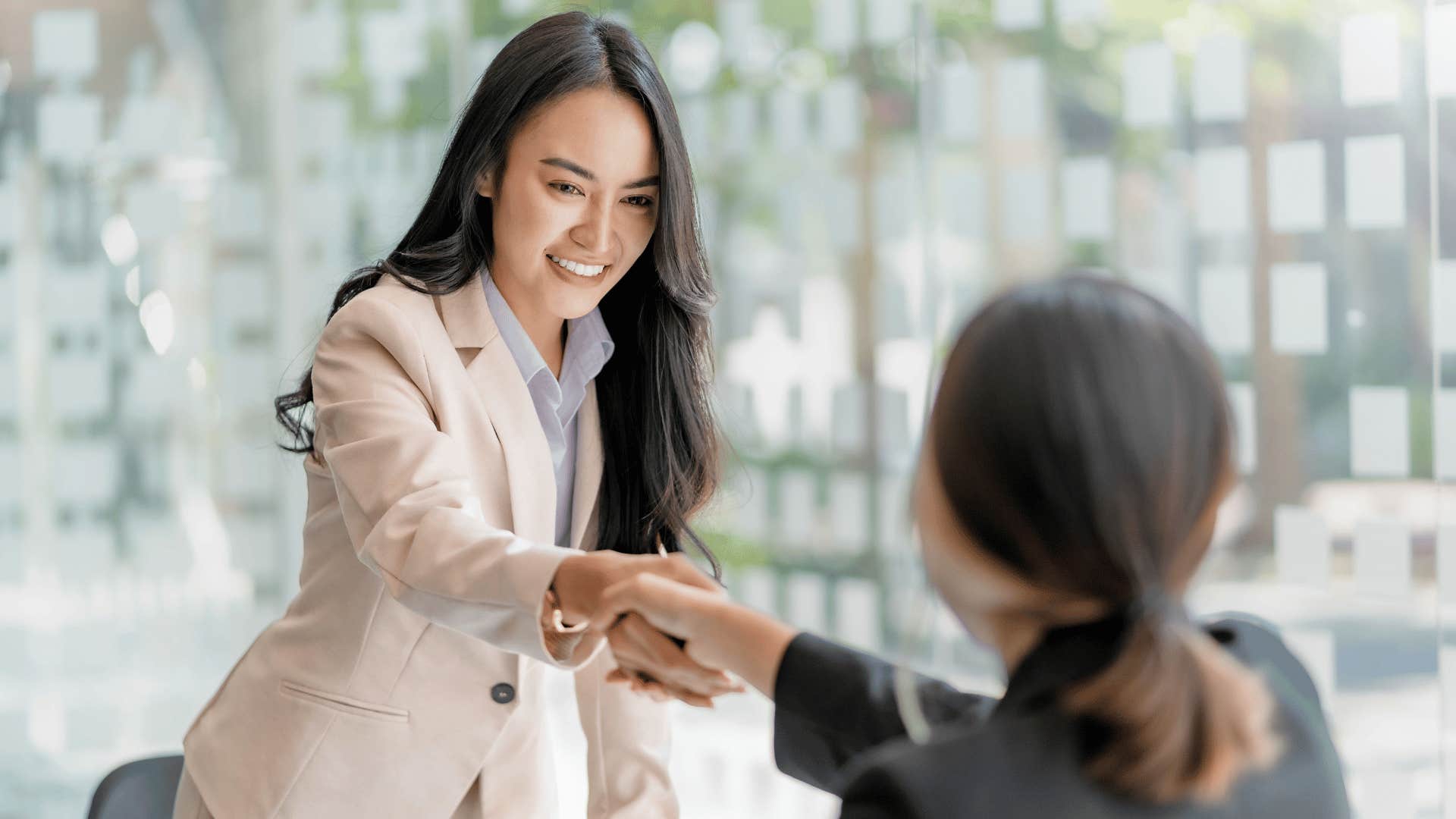 women in an office shaking hands