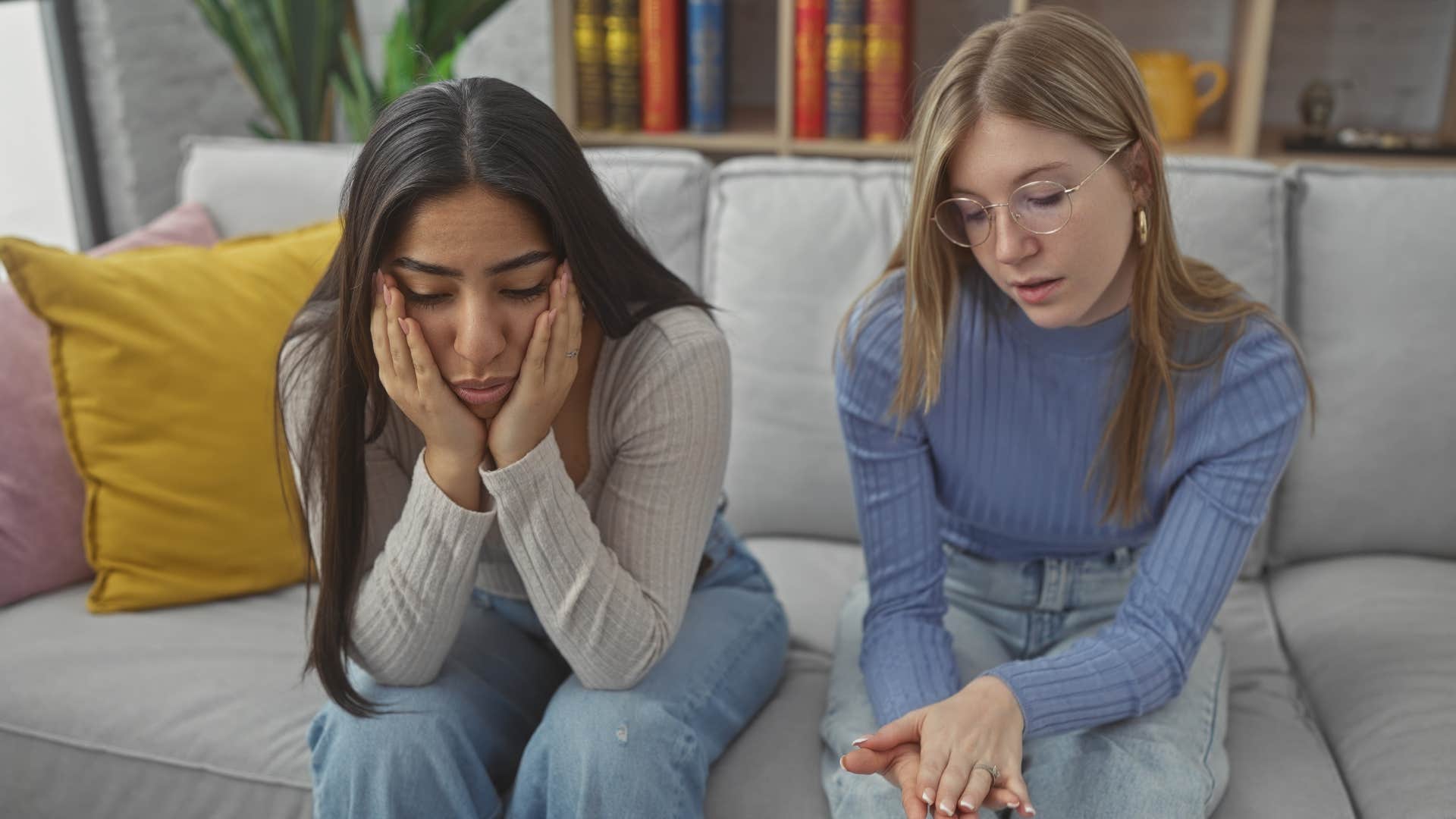 Two women having a serious conversation on a couch.