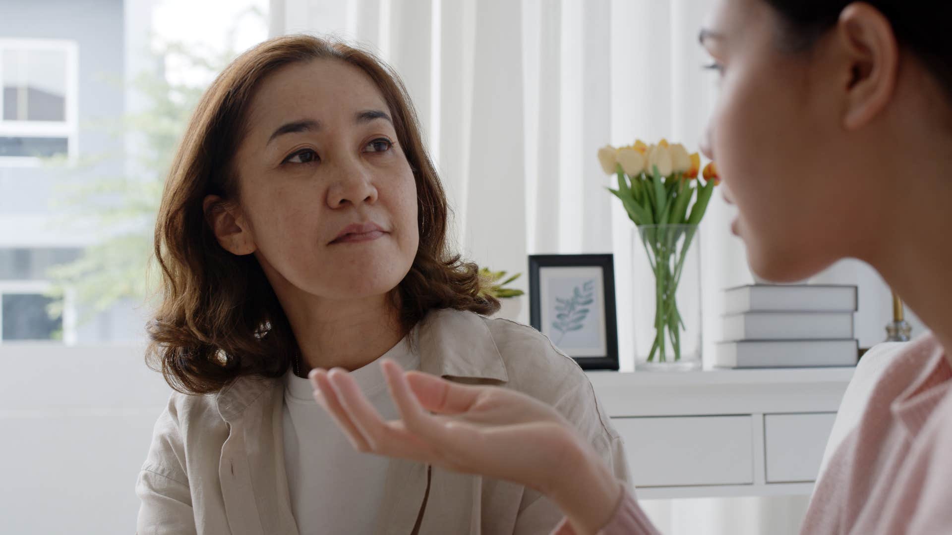 Young woman talking to her upset mother.