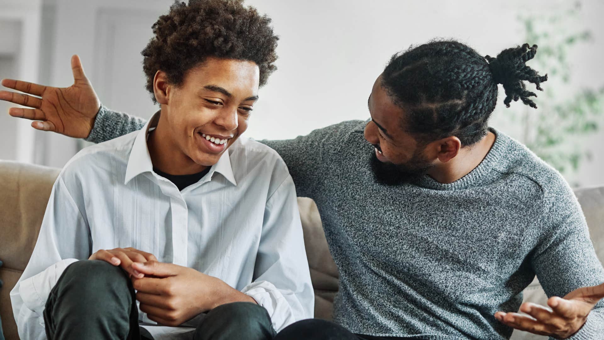 Young boy smiling while talking to his dad