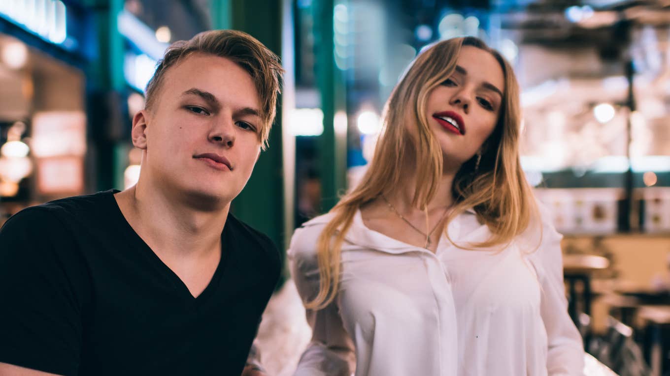 young couple in casual wear standing together and leaning on table