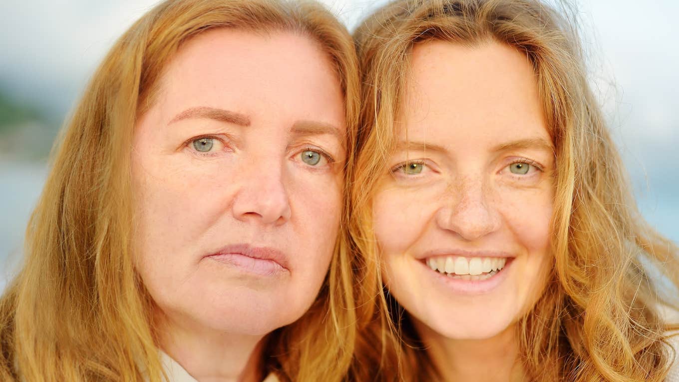 Redhead senior mother and her beautiful adult daughter are walking together and laughing