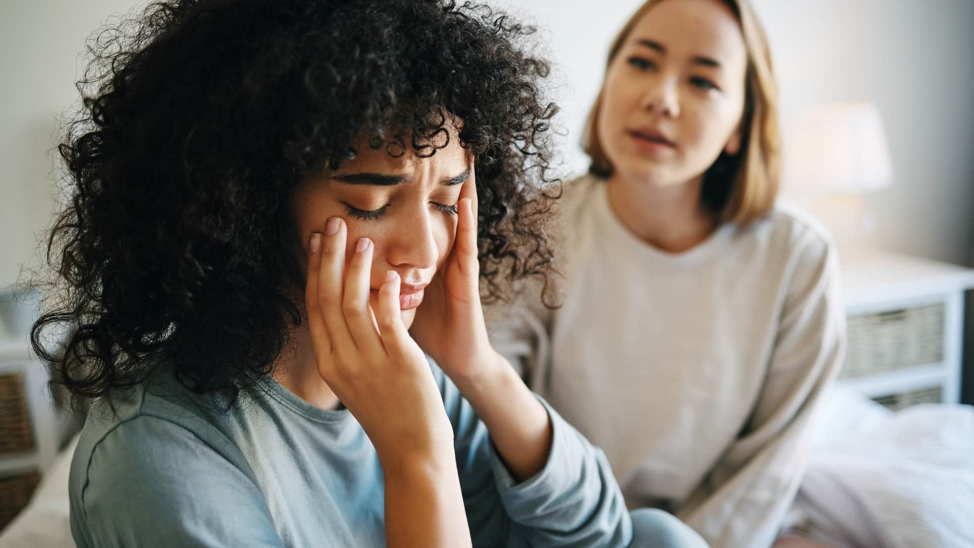 Woman looking sad staring away from her friend.