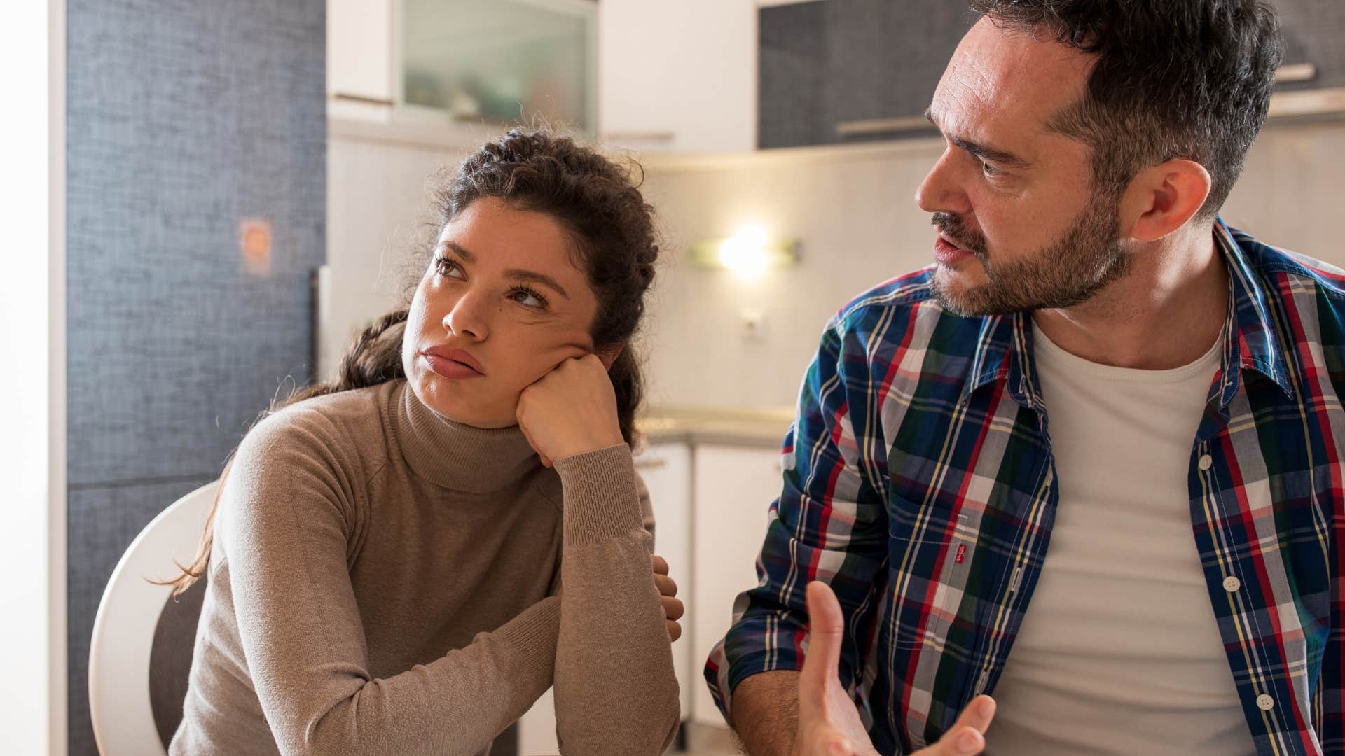 Woman looking annoyed while her husband argues with her.