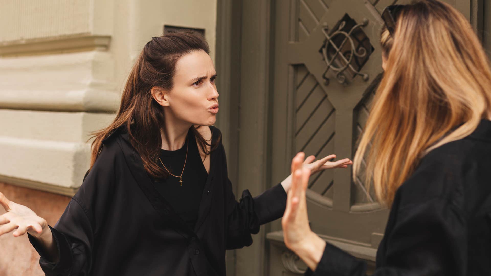 Woman looking annoyed arguing with her friend.