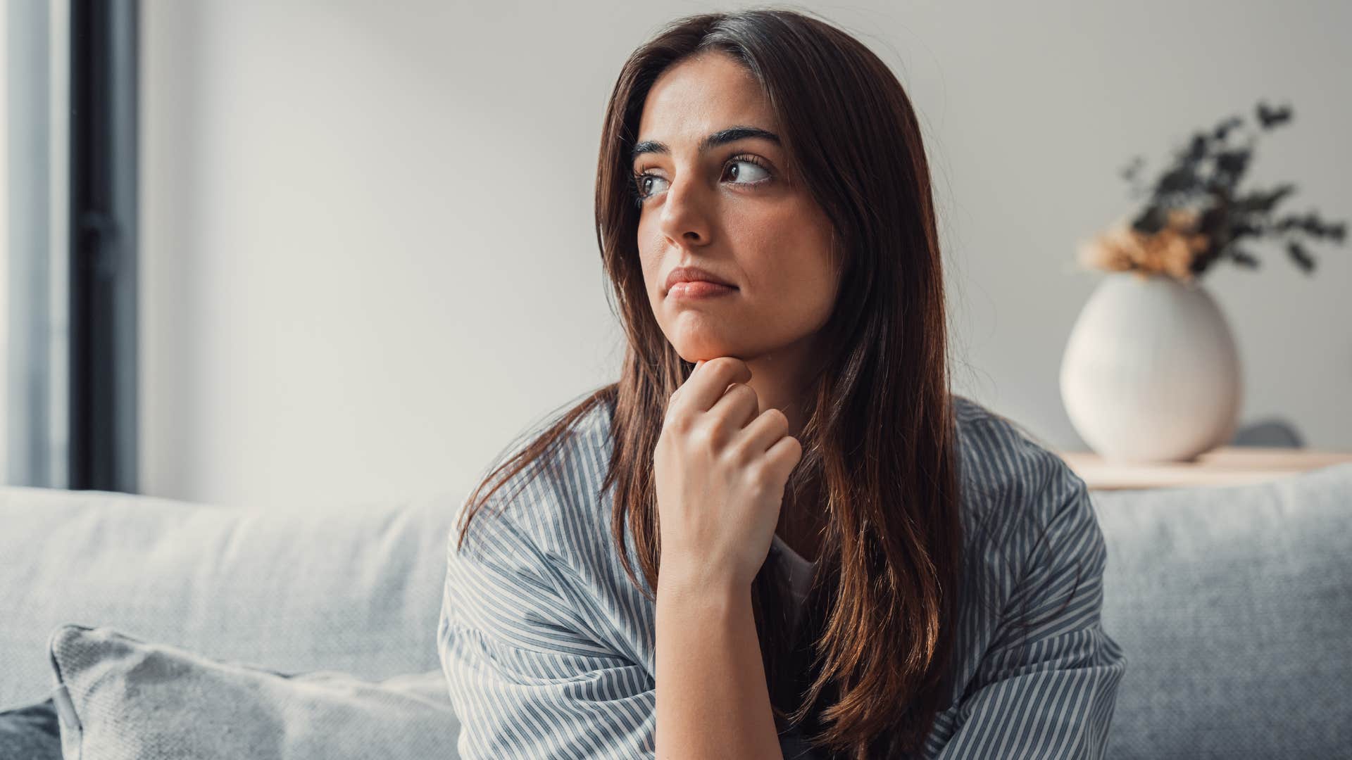 Woman looking annoyed staring out a window.