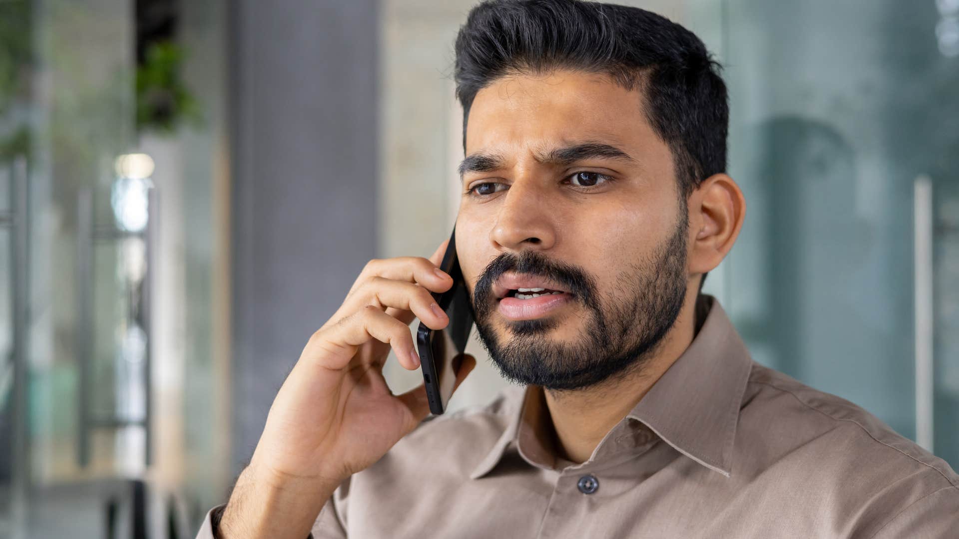 Man looking annoyed talking on the phone.