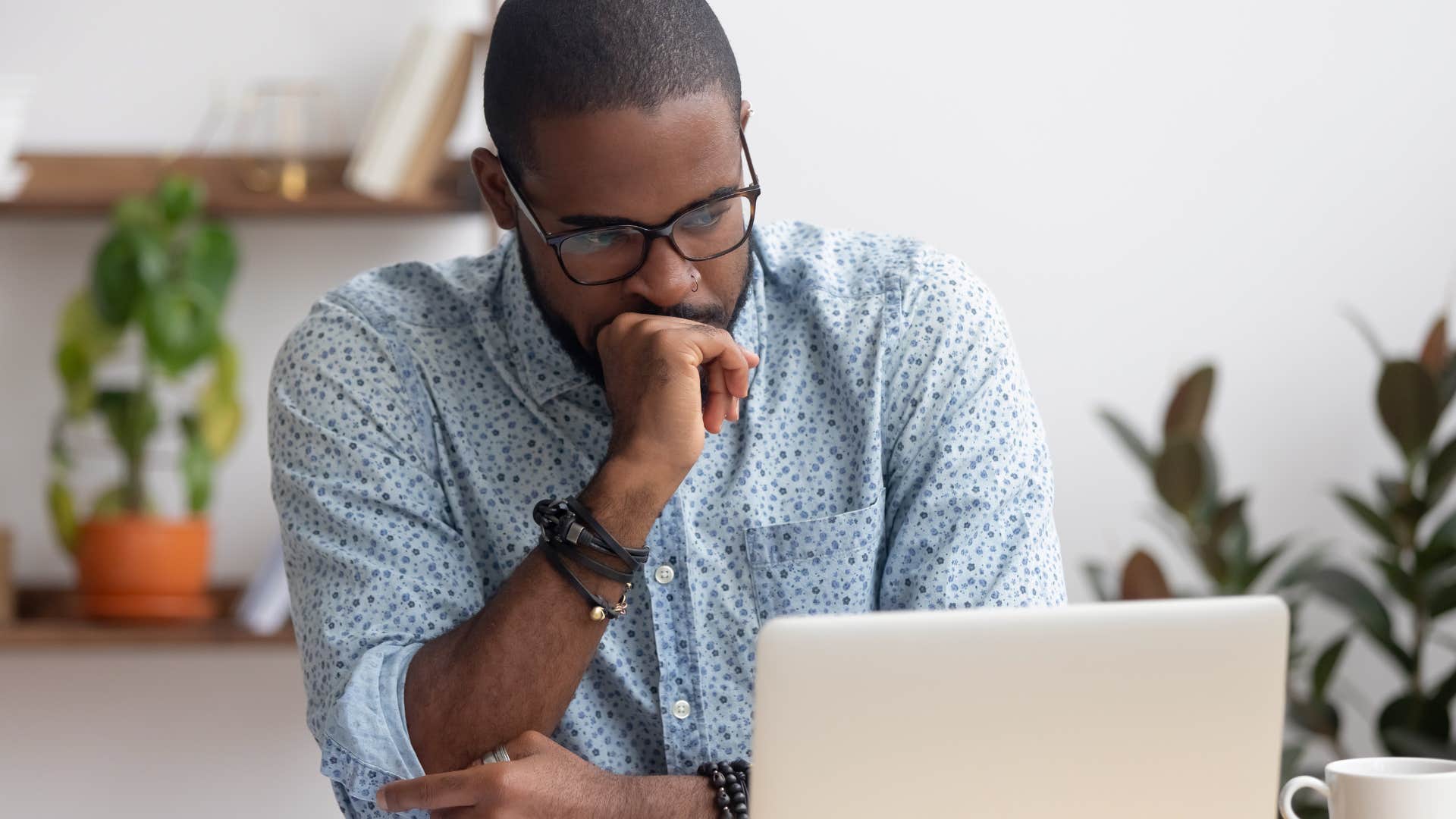 Man looking frustrated staring at his laptop.