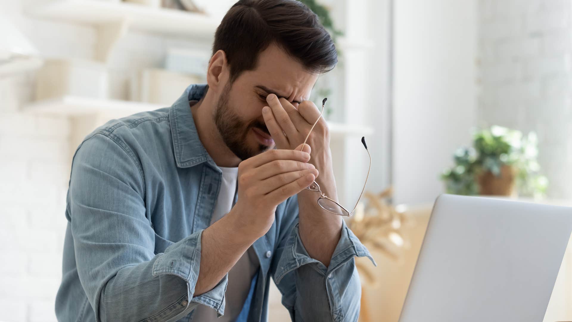 Man looking tired staring at his laptop.