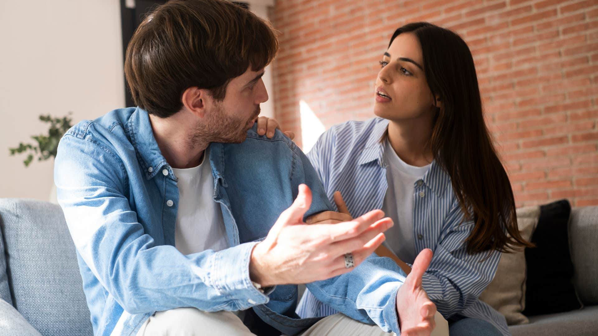 Man arguing with his girlfriend on the couch.