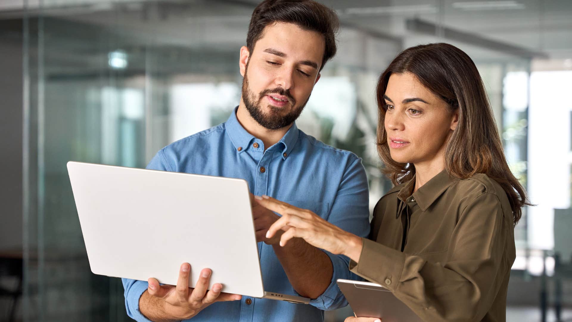 Two work colleagues looking at a laptop together.