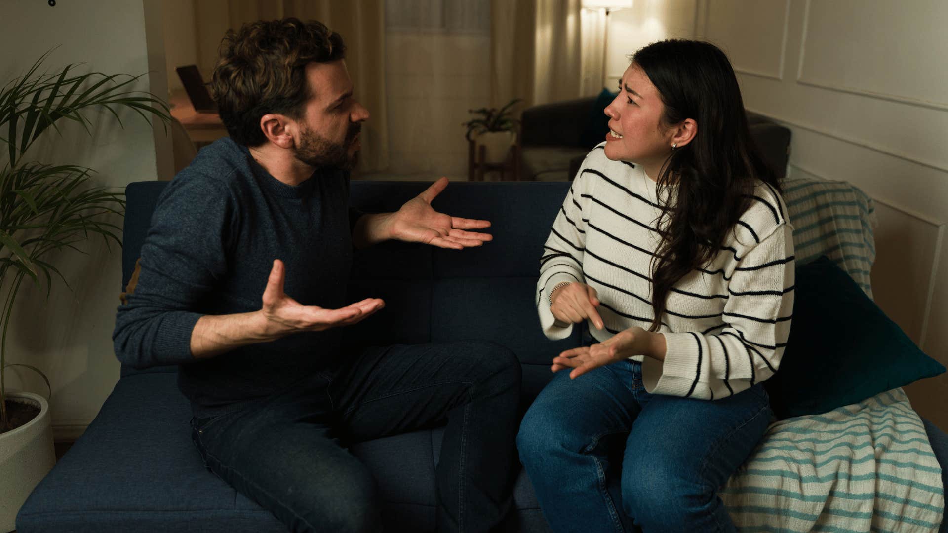 man and woman arguing on the couch intensely 