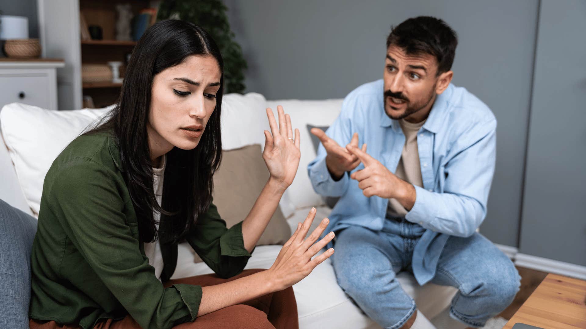 man and woman arguing on the couch