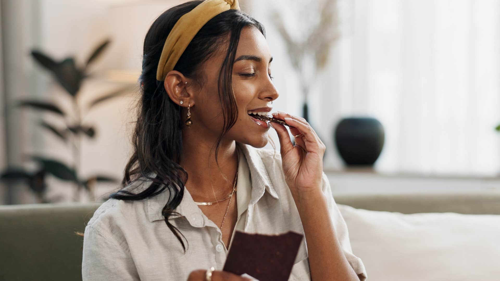 Woman smiling while eating a chocolate bar