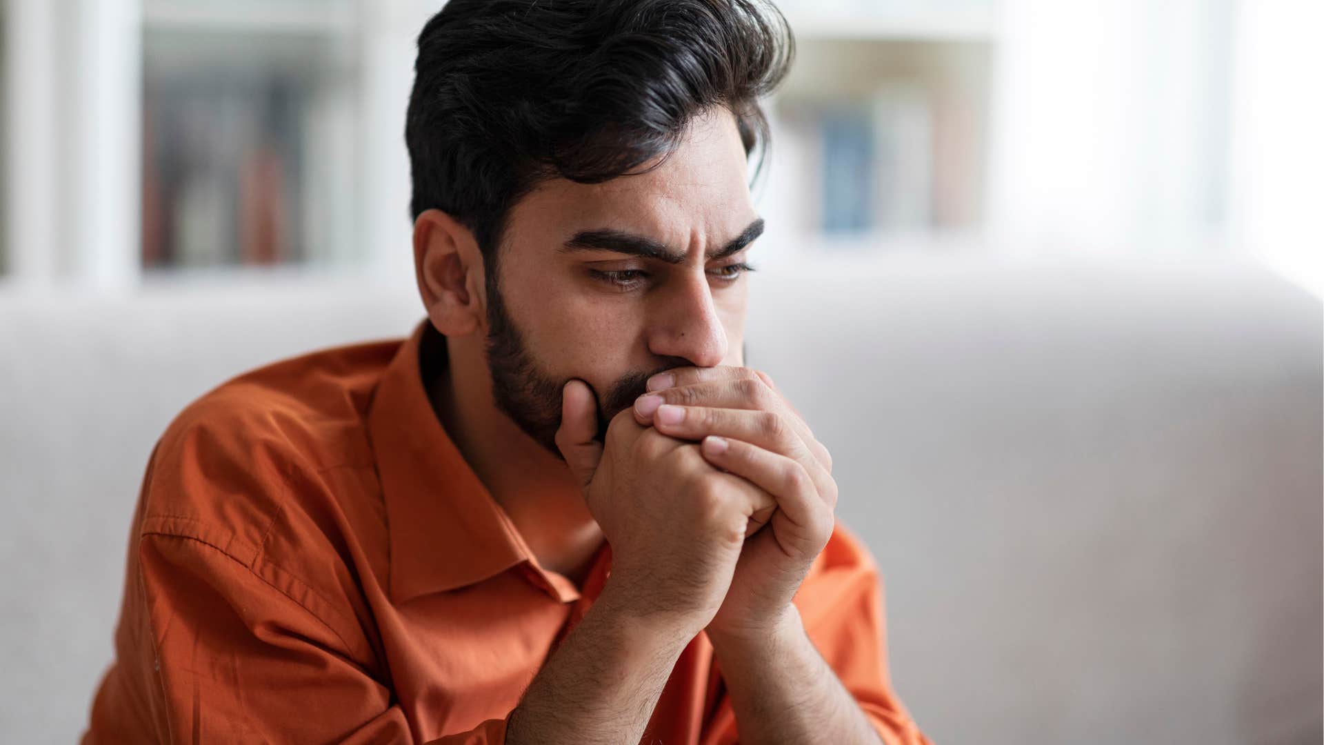 Upset man holding his face in his hands.