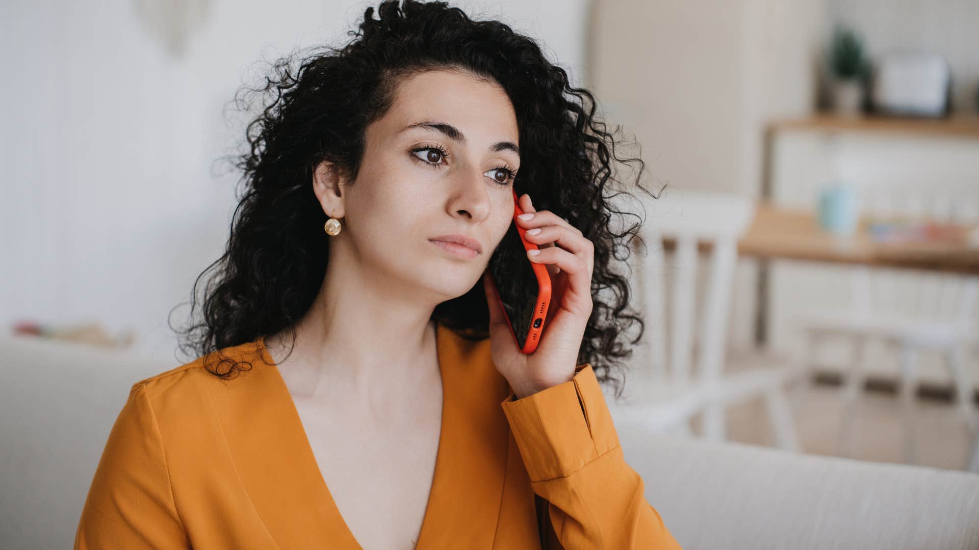 Woman looking sad talking on the phone.