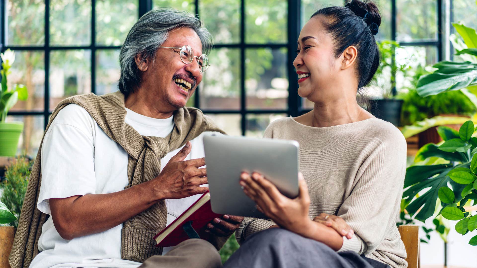 Older couple smiling and talking to each other at home.