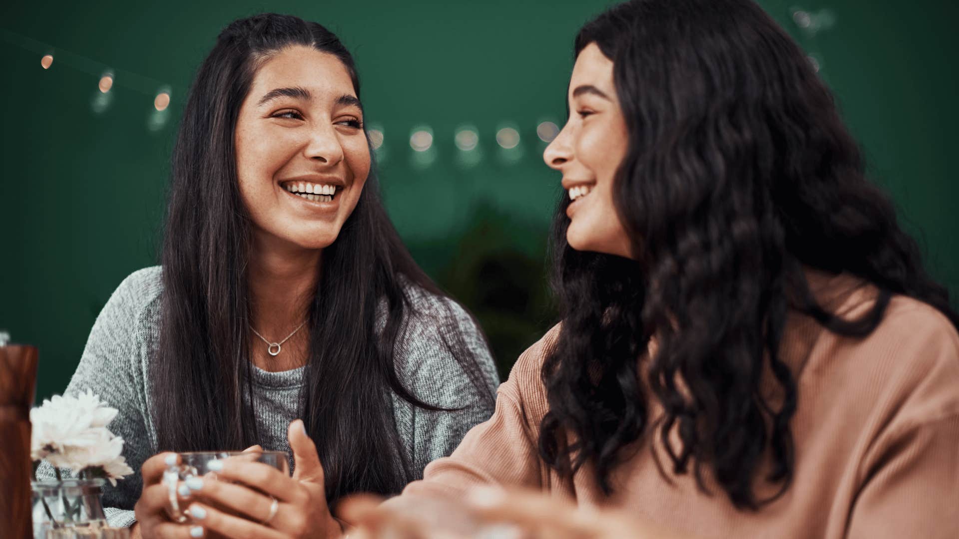 friends sitting next to each other smiling