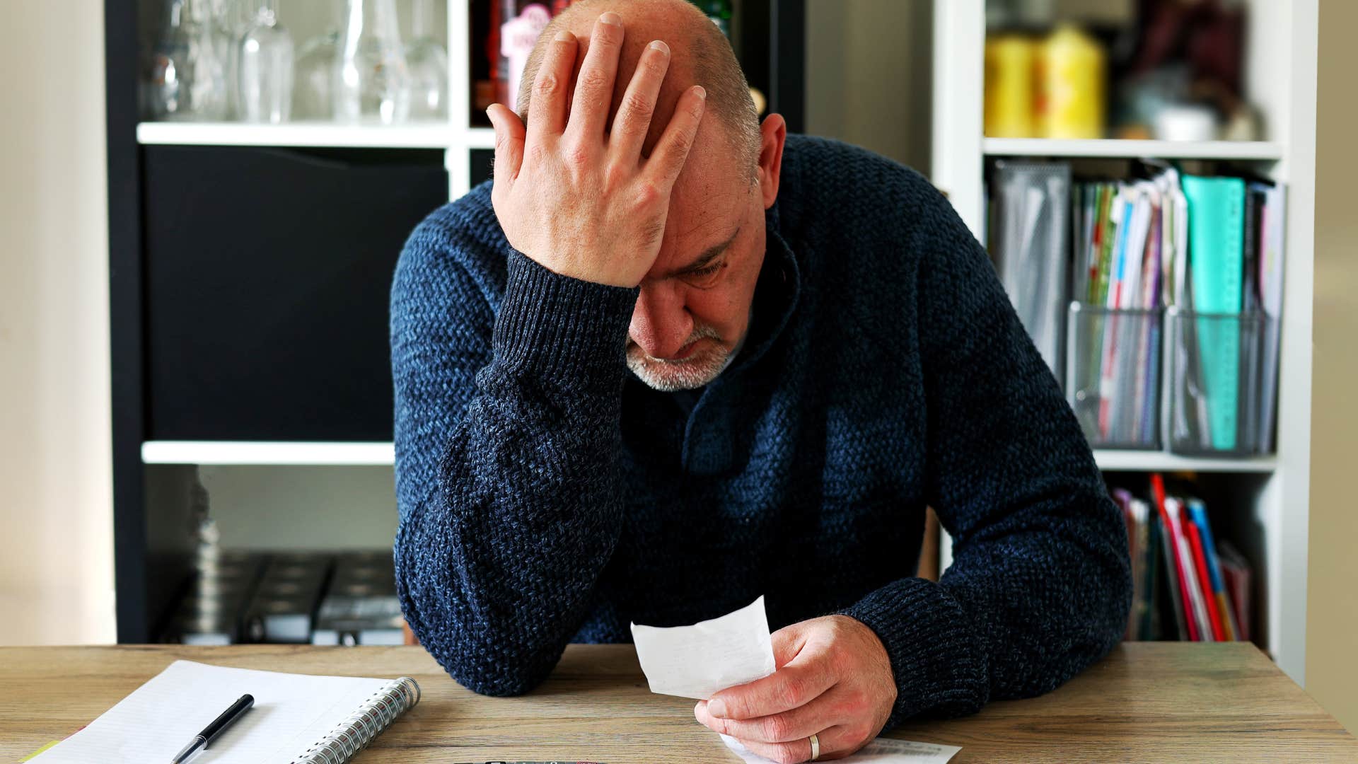 Gen X man looking stressed staring at a receipt