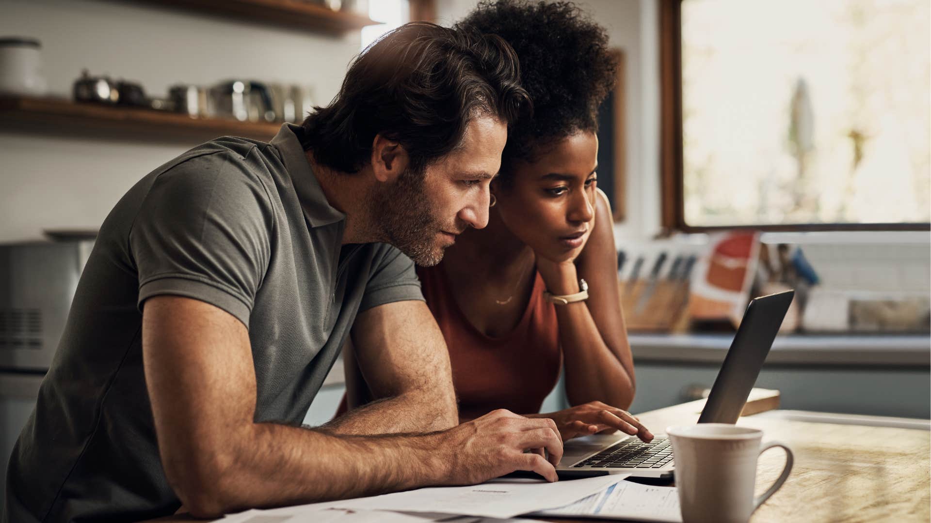 Gen X couple doing bills together and looking at their computer