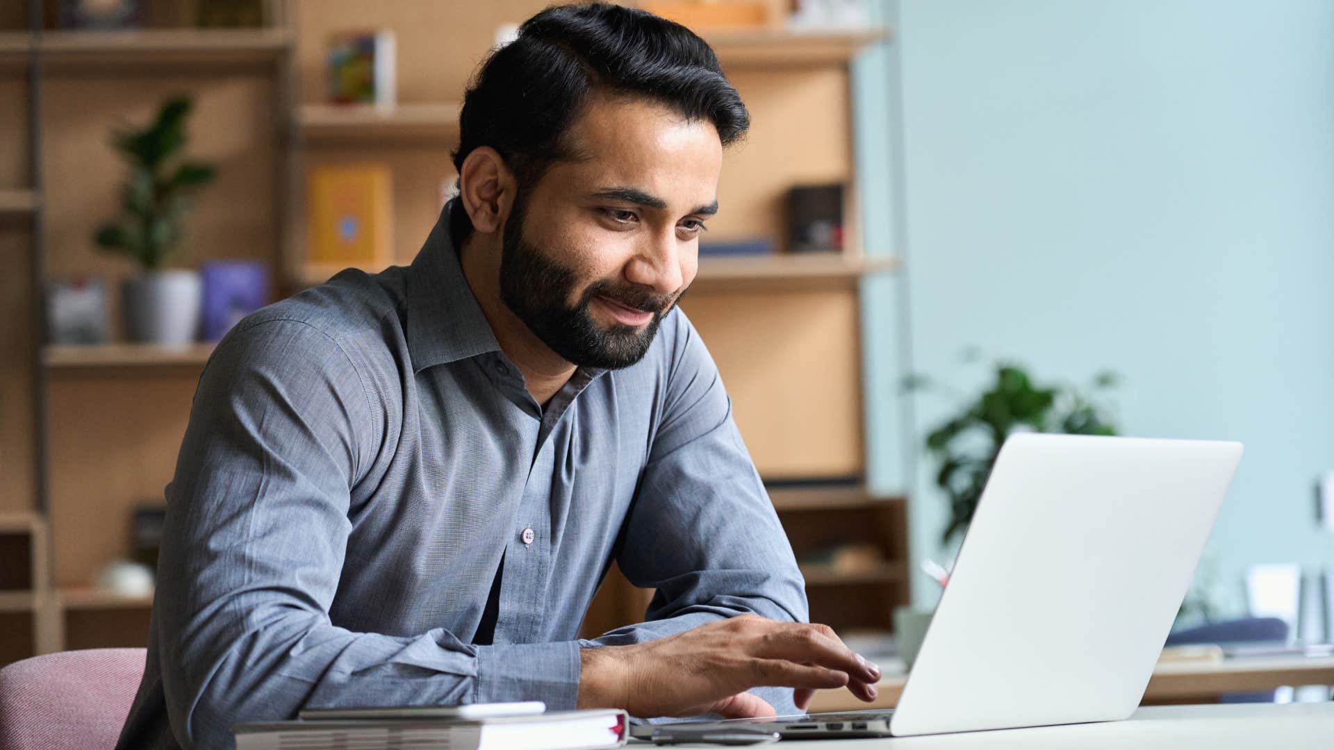 Man smiling while working on his laptop