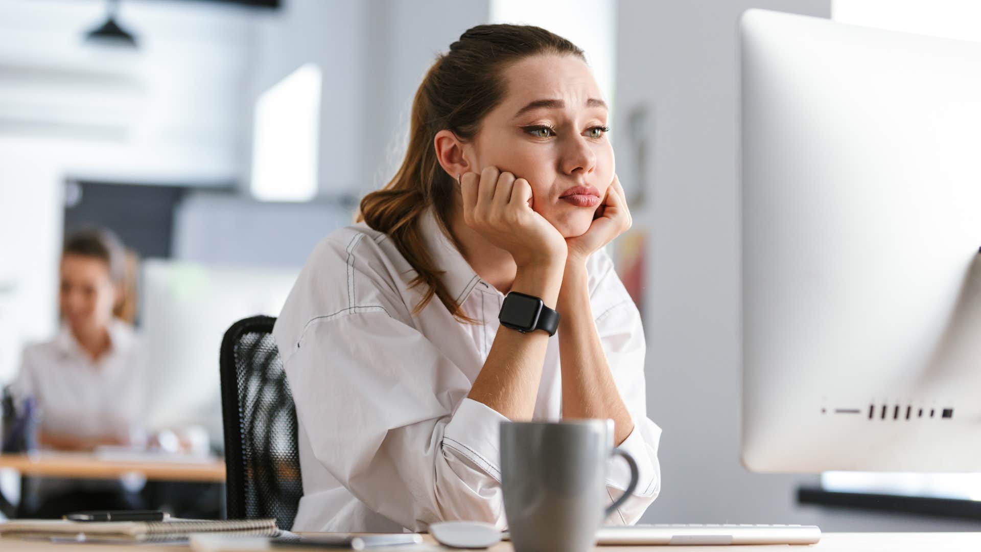 Woman looking bored sitting in front of her laptop