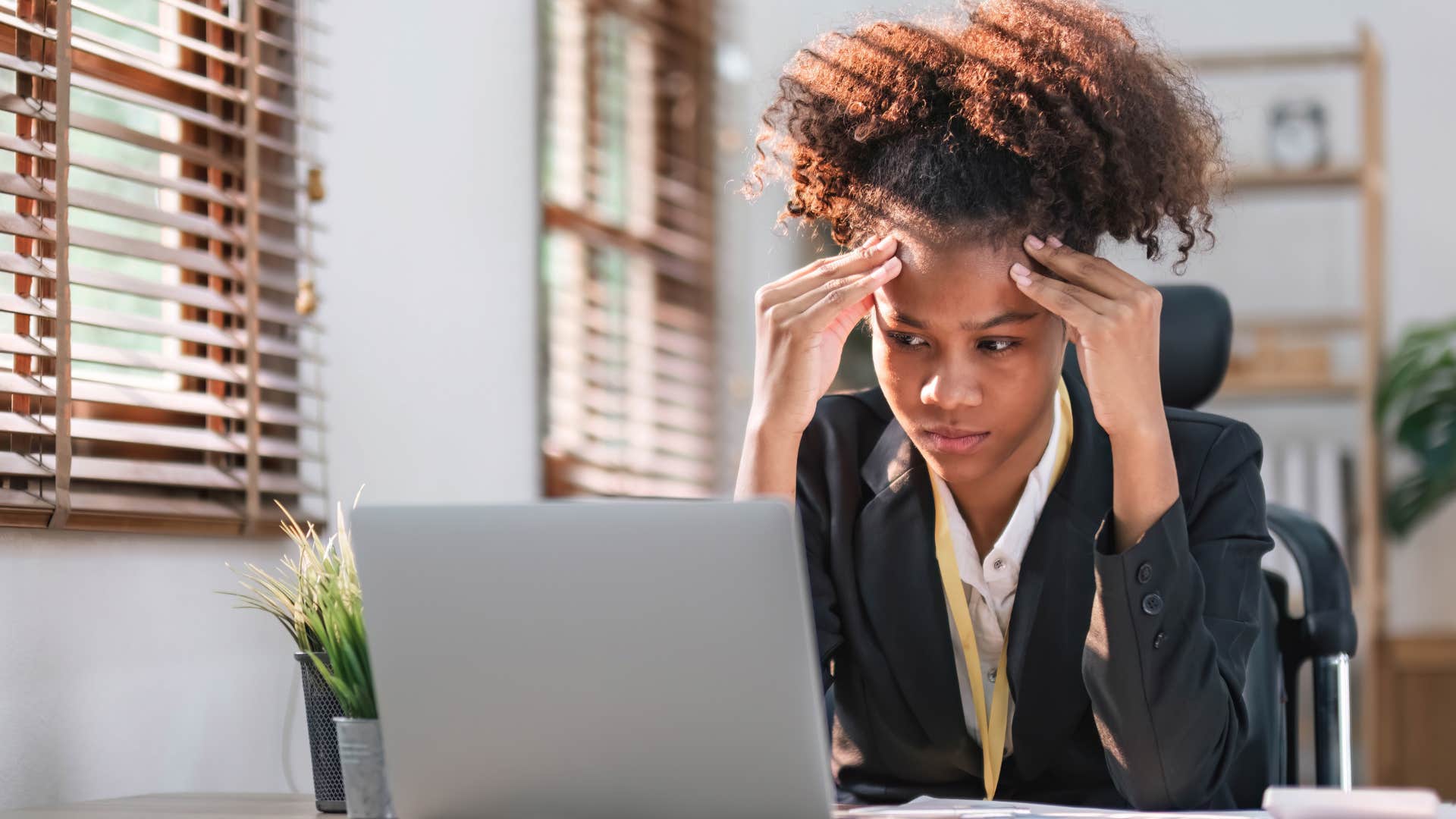 Gen Z worker looking stressed at her desk