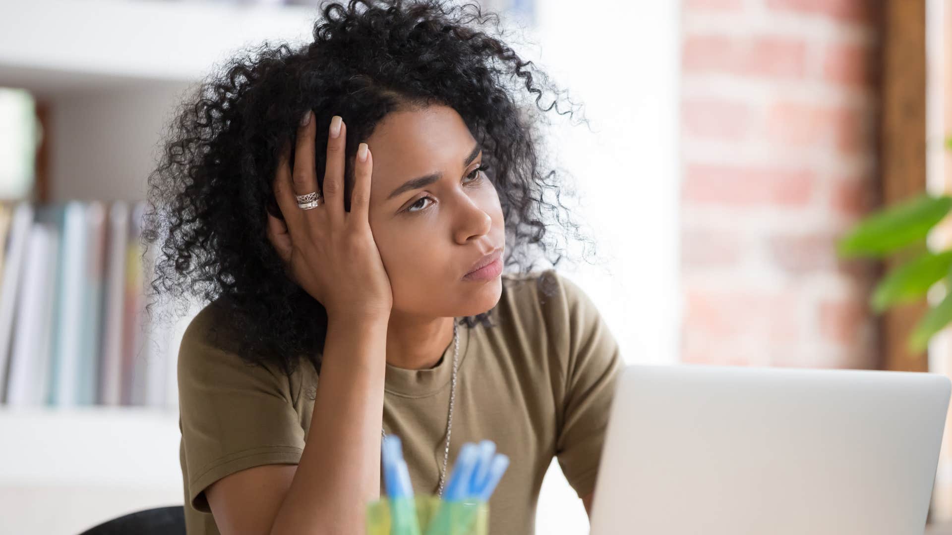 Woman looking stressed in front of her laptop at work