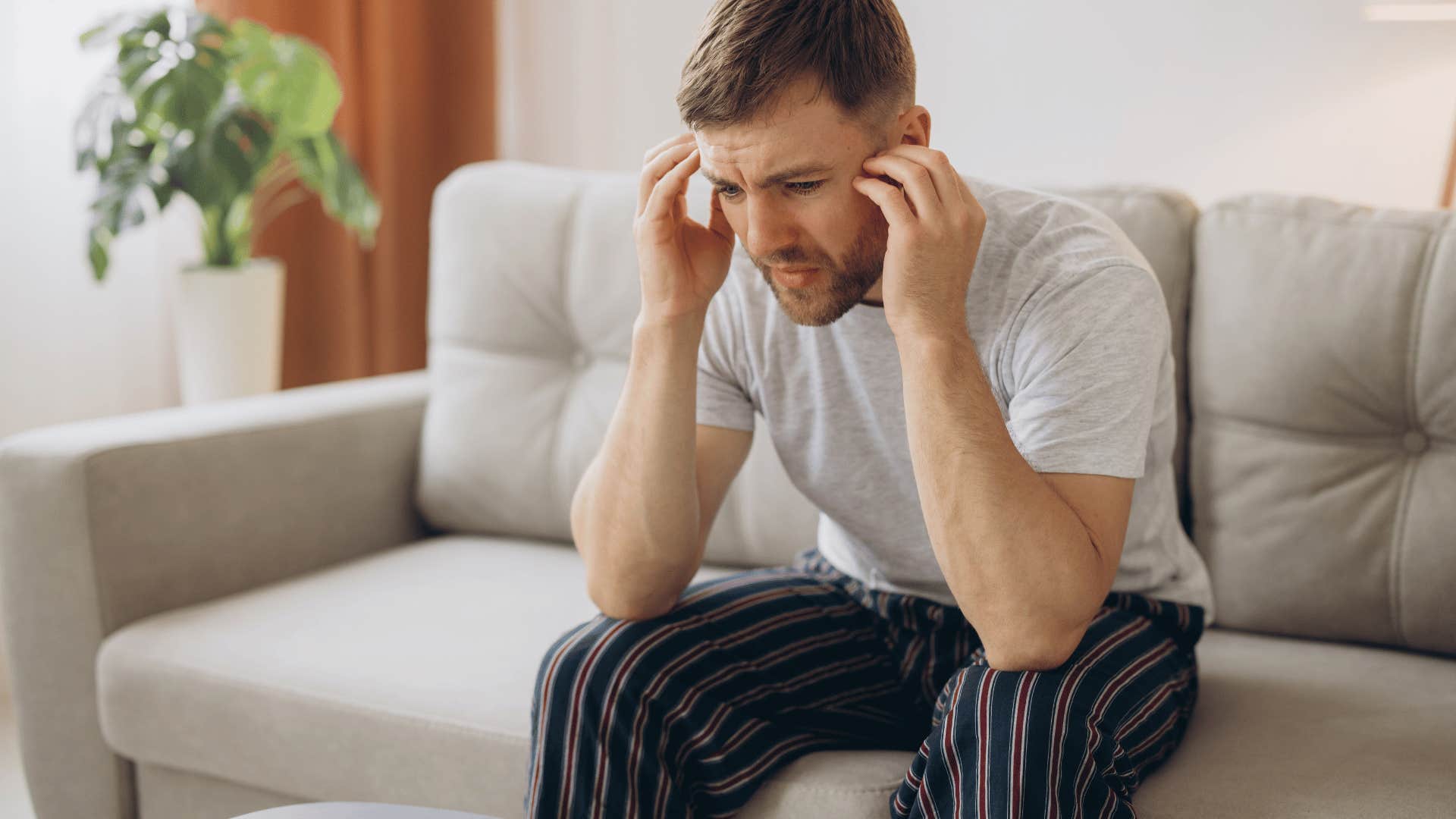 man crying on couch