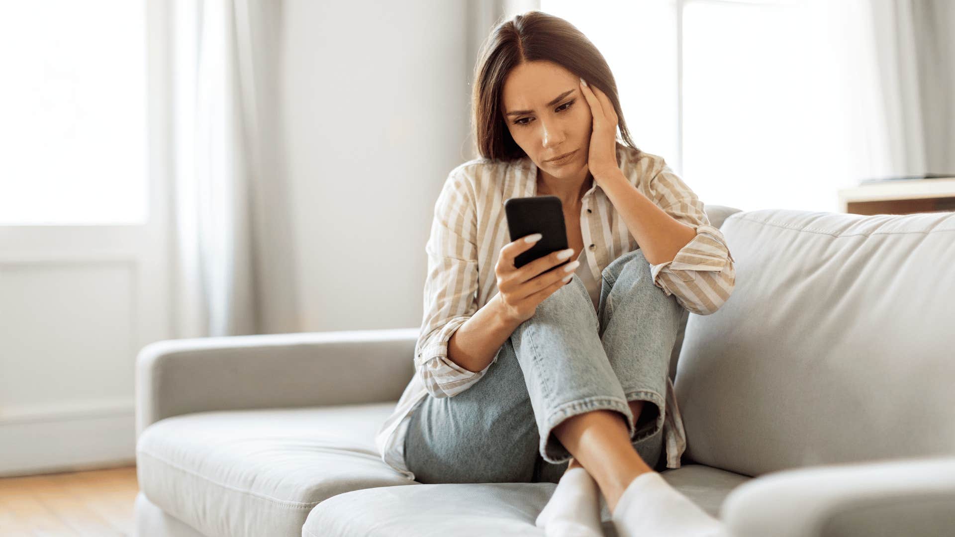 woman upset looking at phone