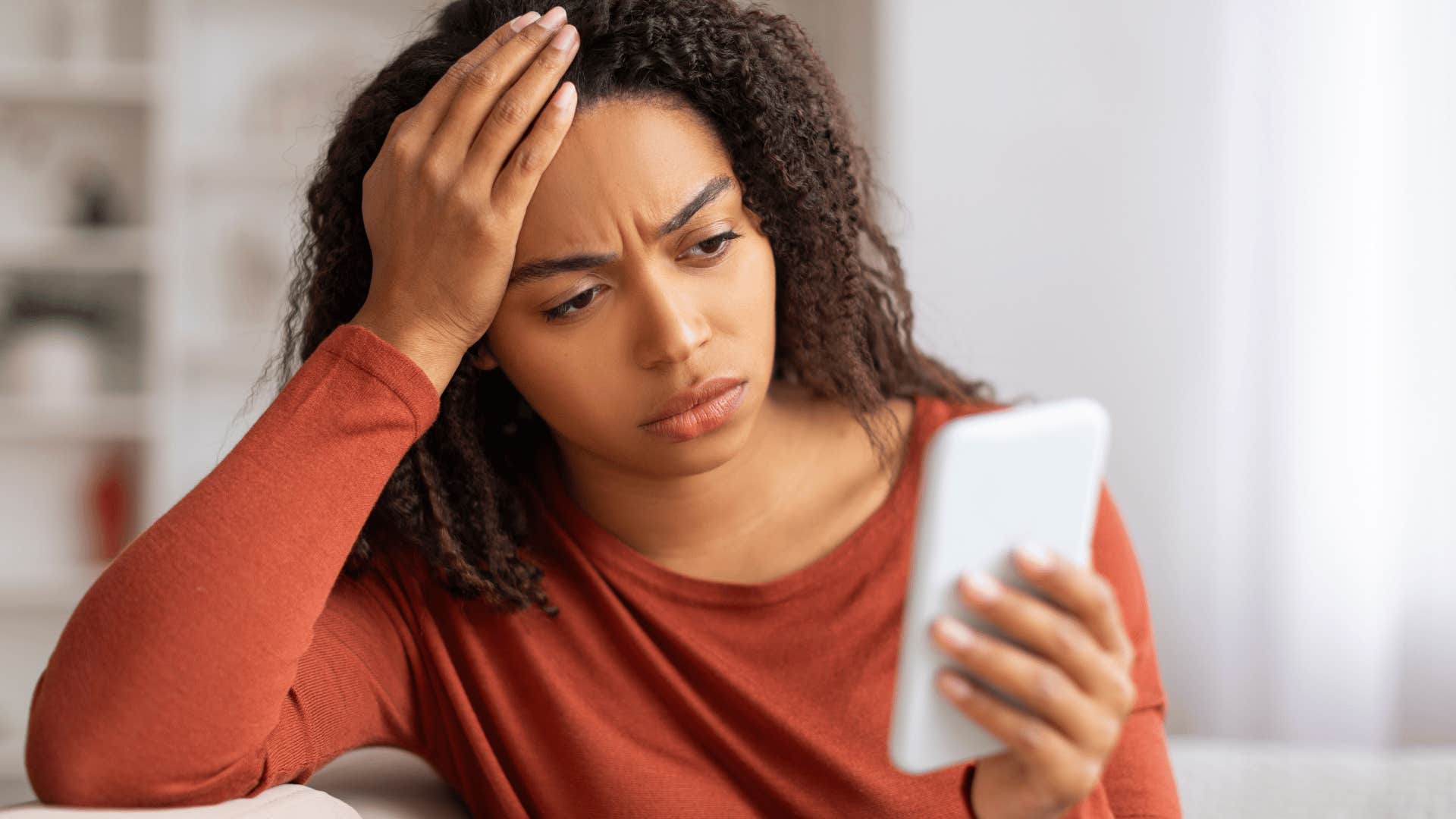 upset woman looking at phone