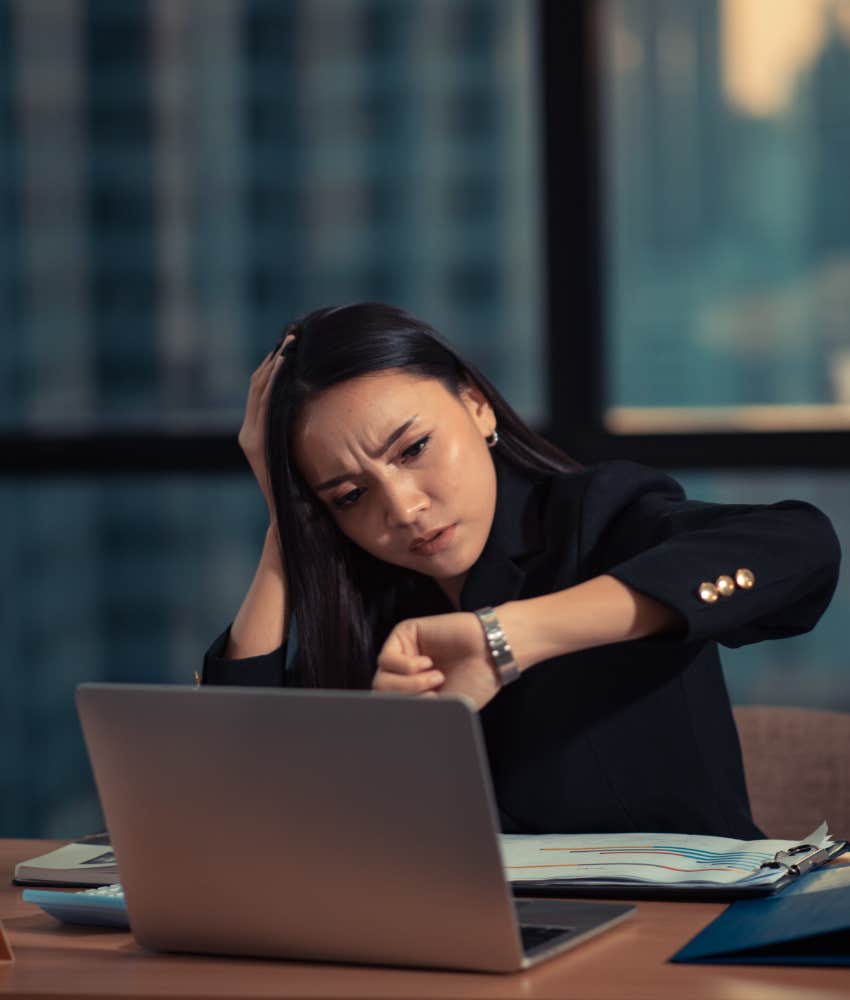 woman checking her watch after long hours at work