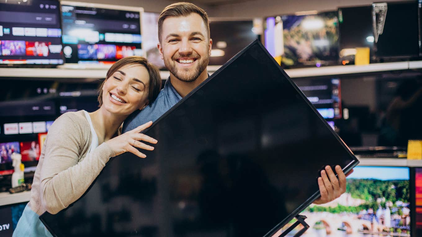 Couple holding the TV they stole on Black Friday