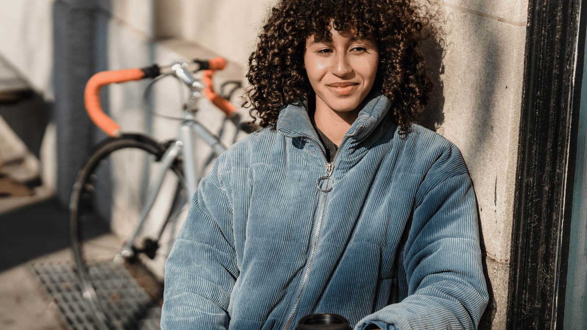 woman smiling while sitting down with coffee