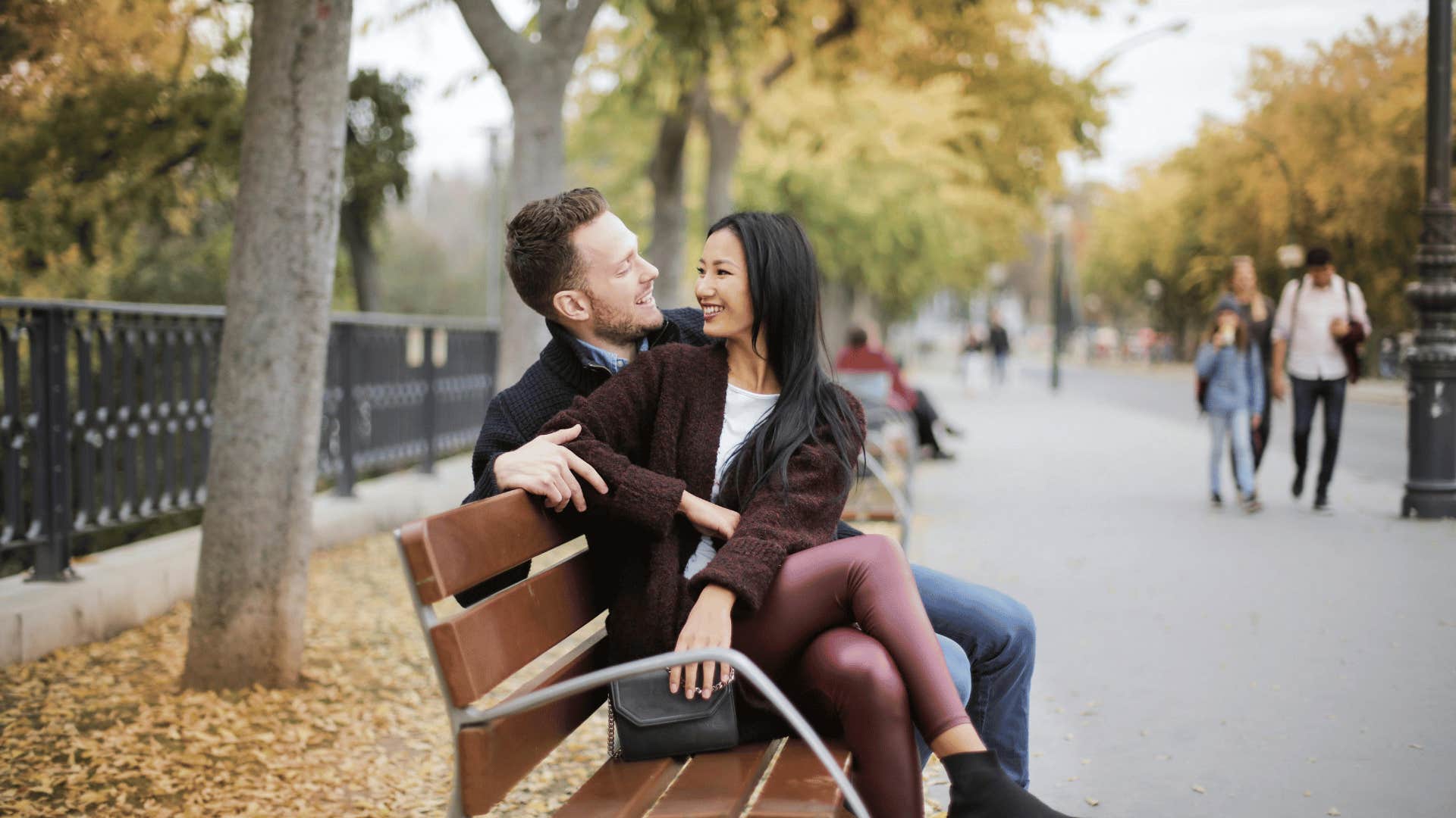 woman and man sitting on park bench