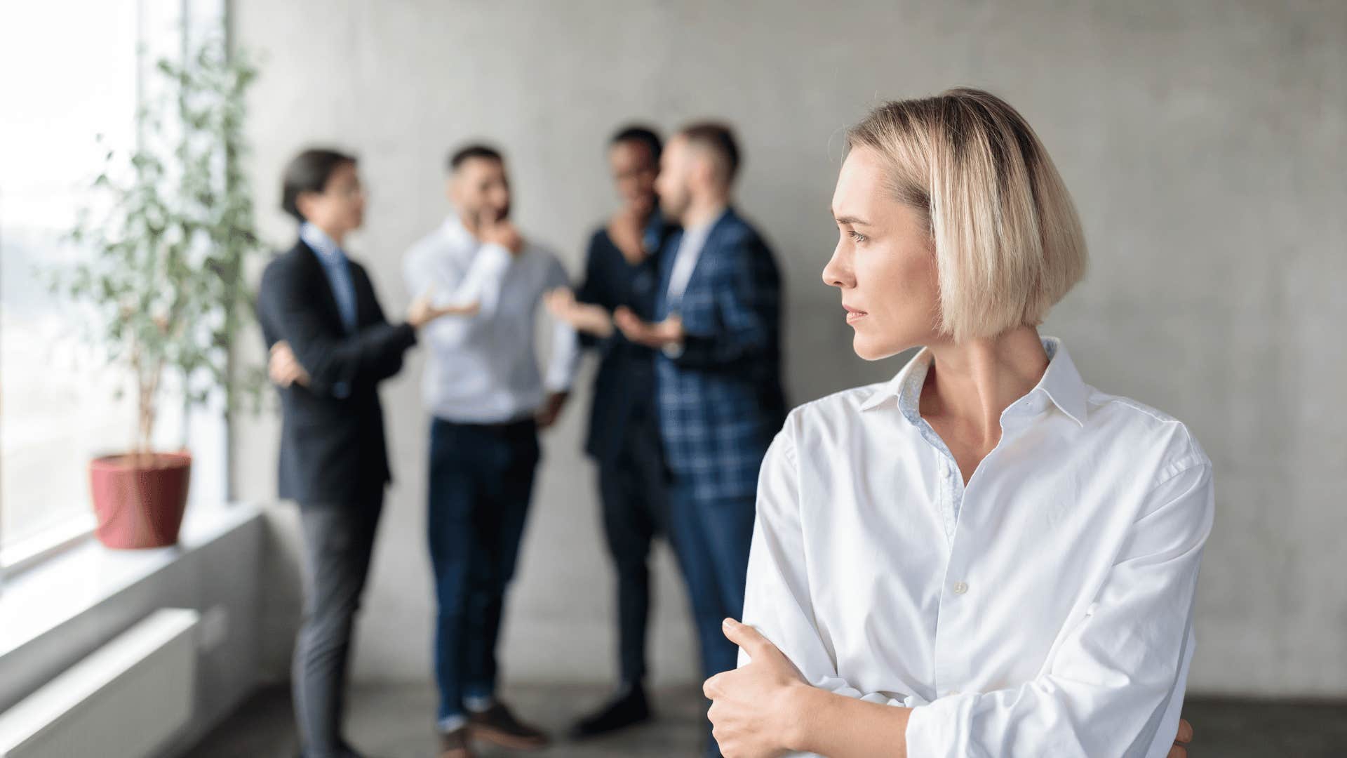 group of people gossiping behind woman