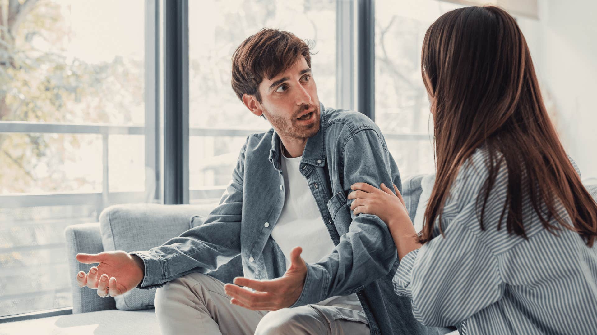 man looking frustrated while woman tries to comfort him