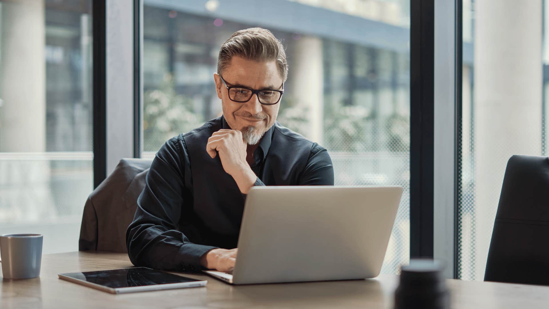 man smiling and looking at laptop