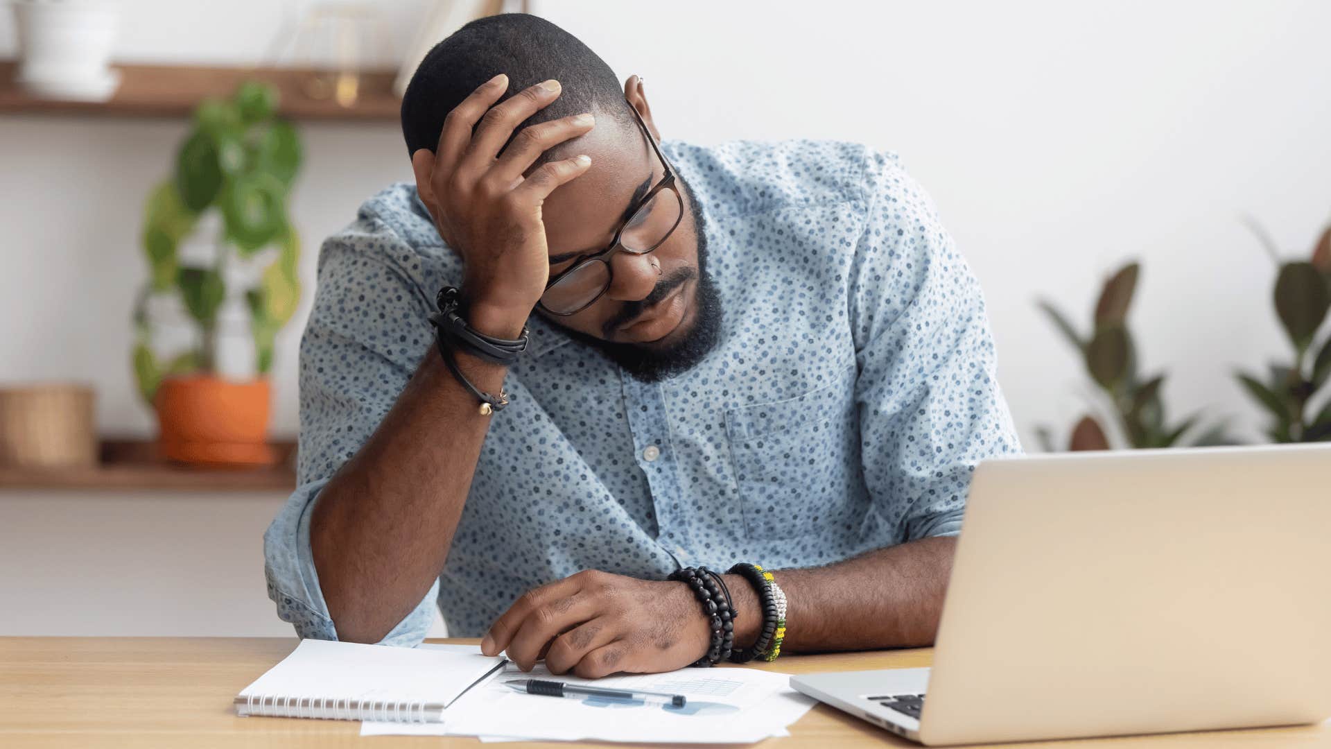 man frustrated while staring at laptop