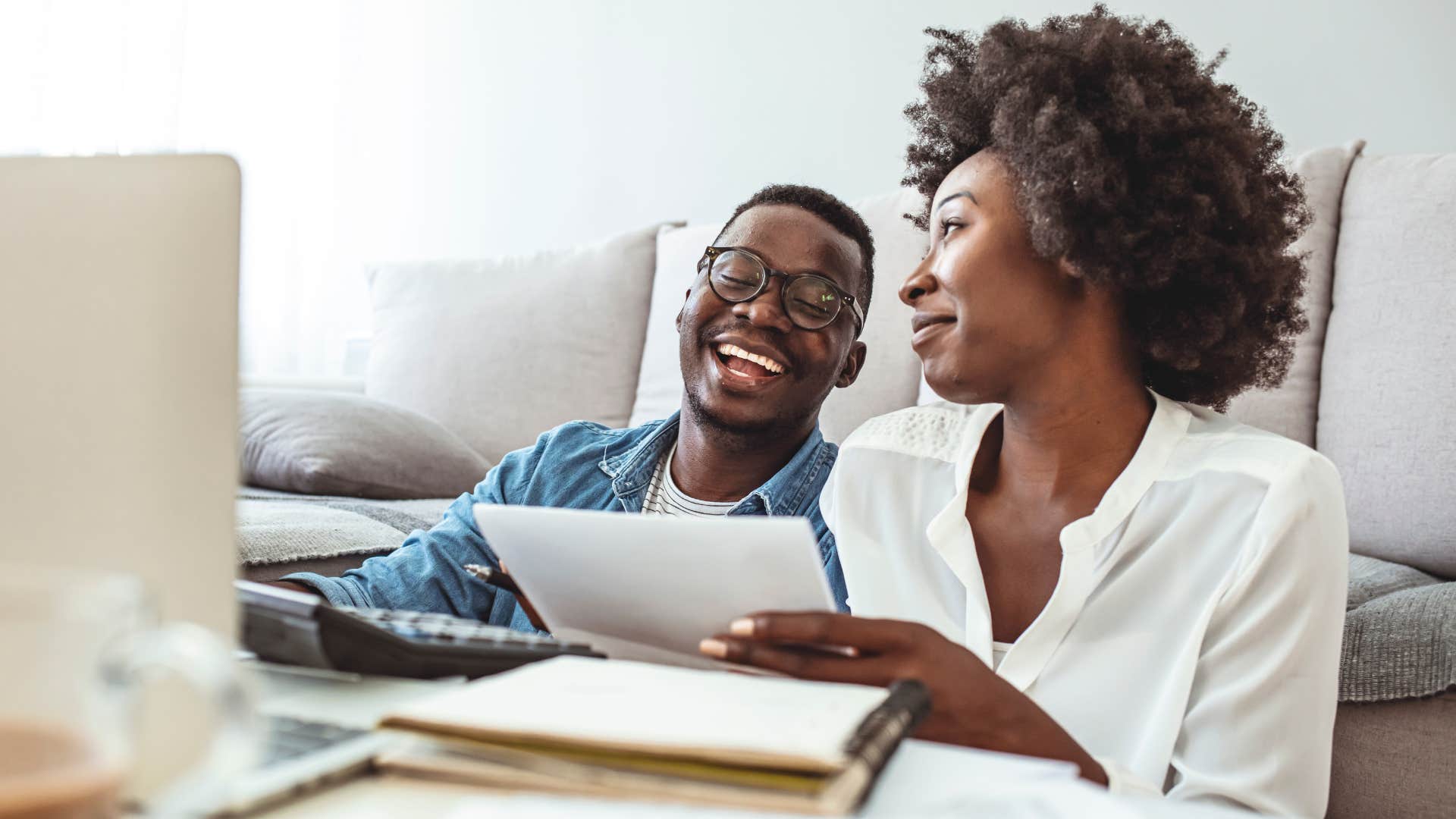 Woman smiling while doing bills with her husband.