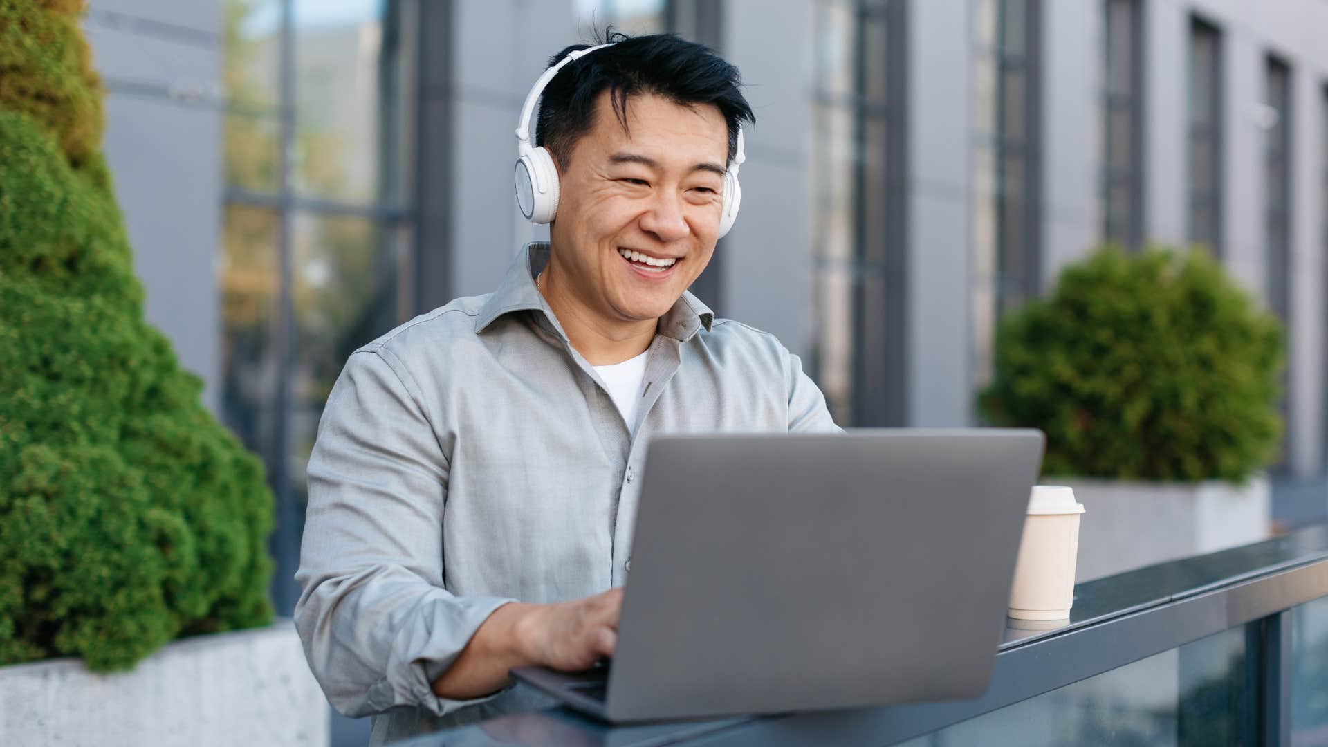 Man smiling while working on his laptop.