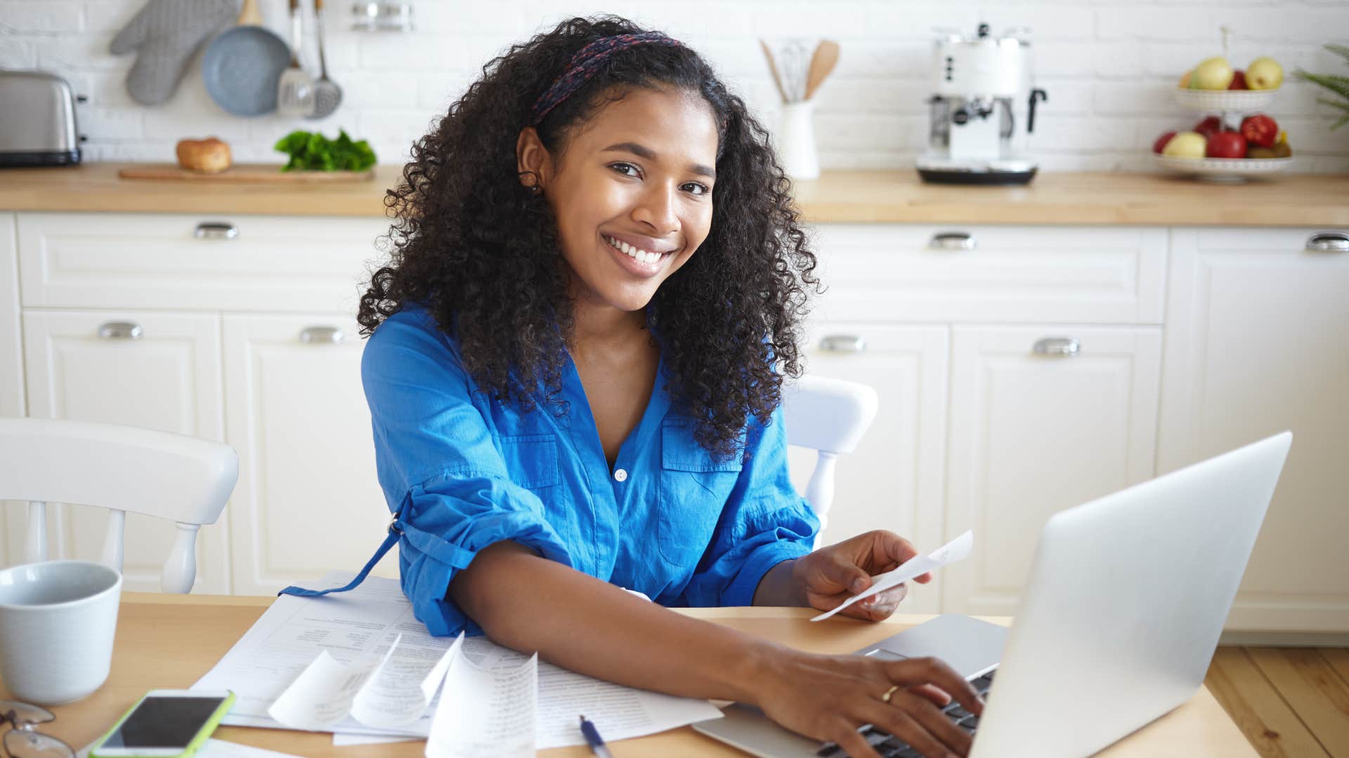 Woman smiling and typing on her laptop.