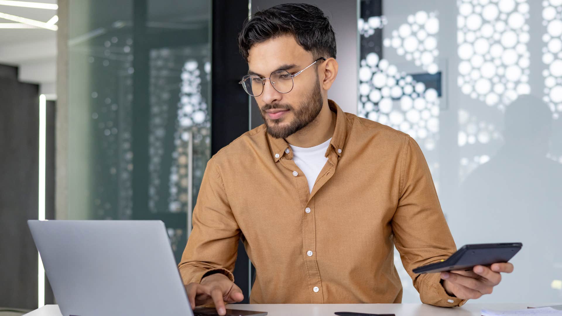 Man doing bills on his computer at work.