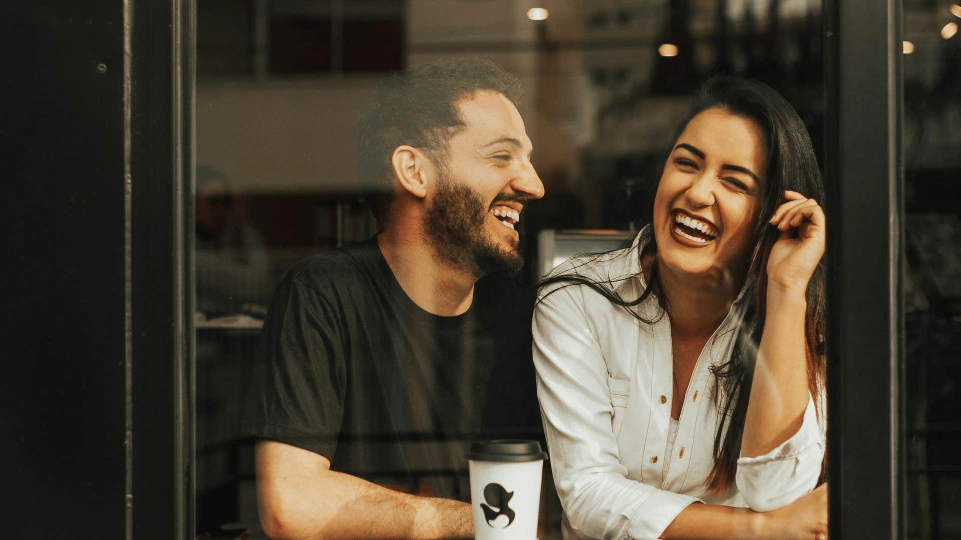 man and woman sitting close together and laughing